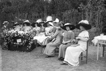 Senyoretes en una parada de flors, que es venien a una pesseta, durant la vetllada esportiva organitzada per la baronessa de Maldà, a benefici de les víctimes de la campanya del Rif, any 1912. AGDB. Fons i autoria: Frederic Juandó Alegret.